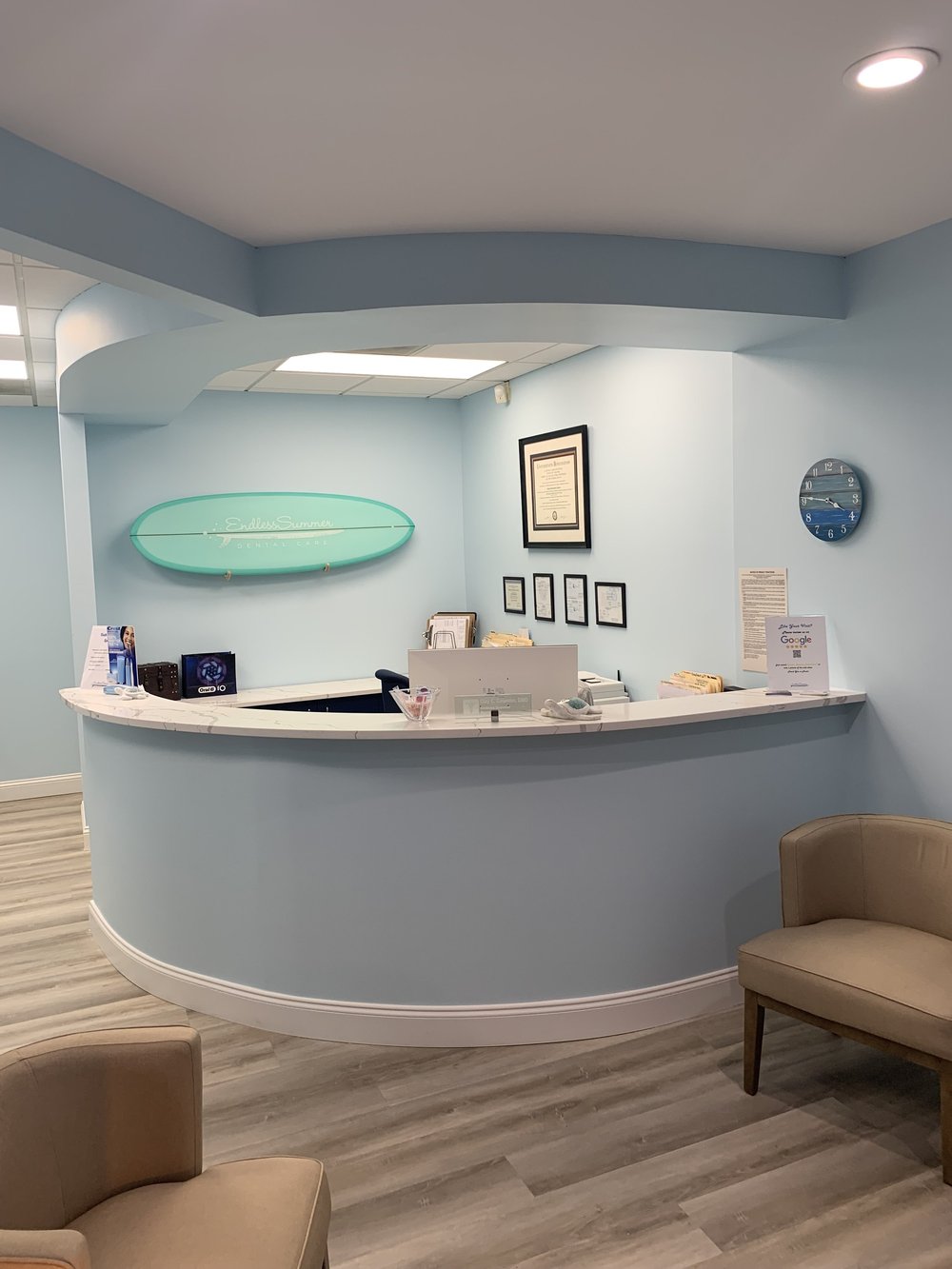 Curved reception desk and surfboard decor at Endless Summer Dental Care